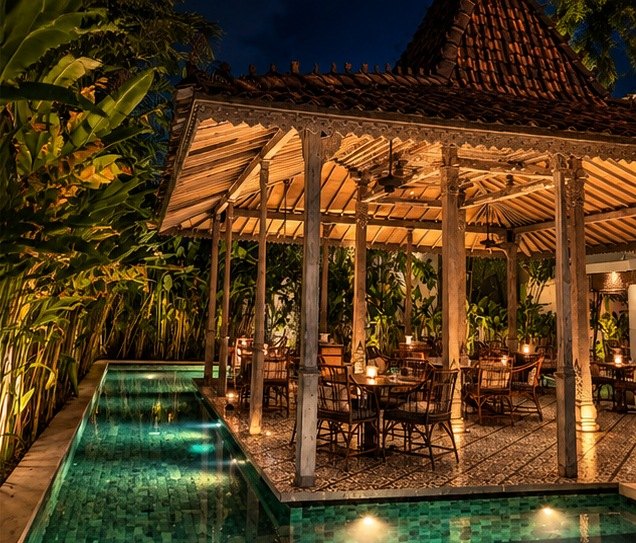 Candlelit dining pavilion beside a green-tiled pool at night